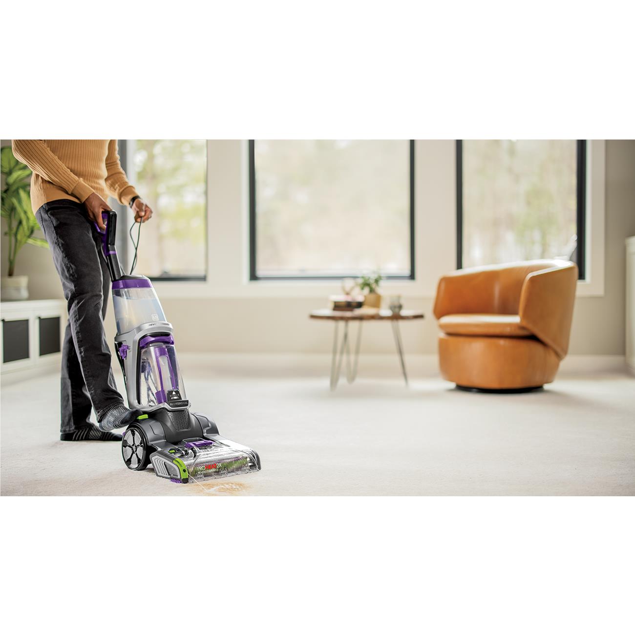 Upright carpet cleaner with purple handle and brush nozzle, black body