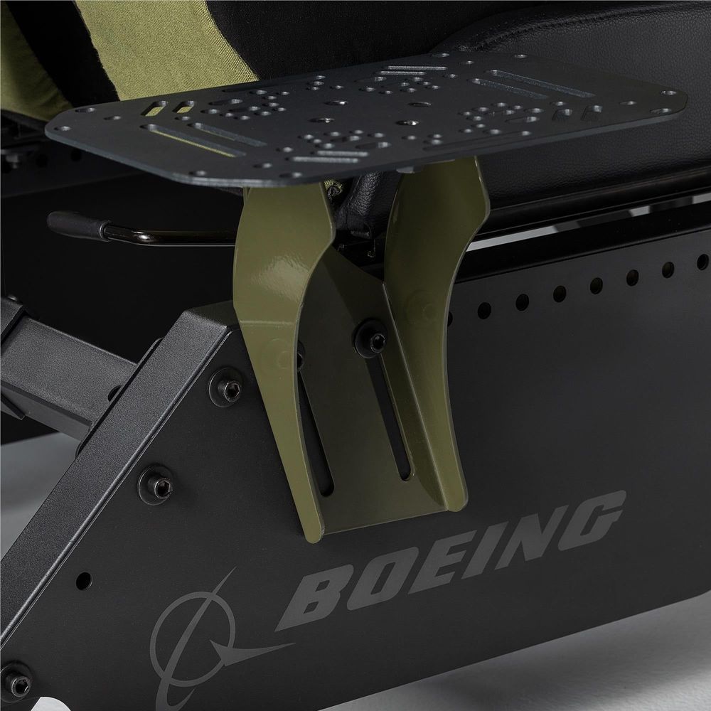 Close-up of simulator cockpit armrest area with olive support and black metal pedal plate