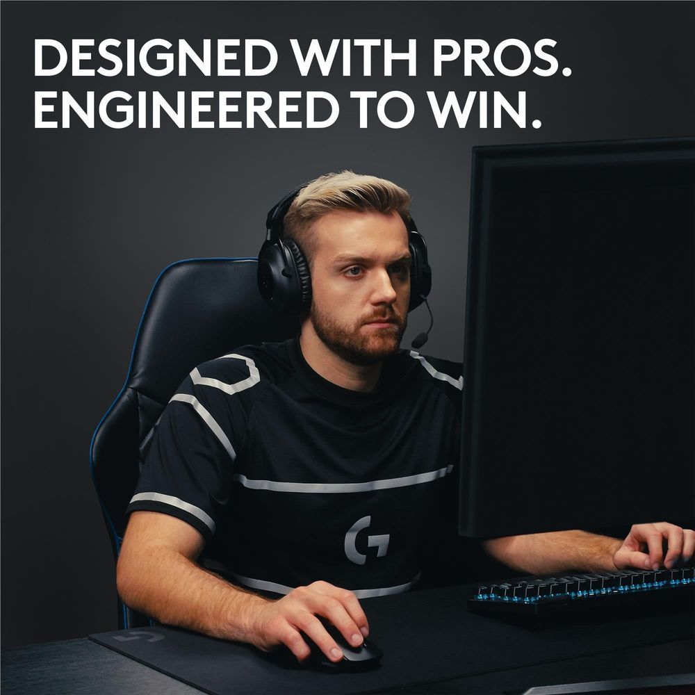 Black wireless gaming mouse in a player's hand near the keyboard