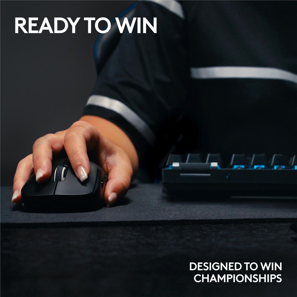 Wireless gaming mouse in use on a desk next to a mechanical keyboard