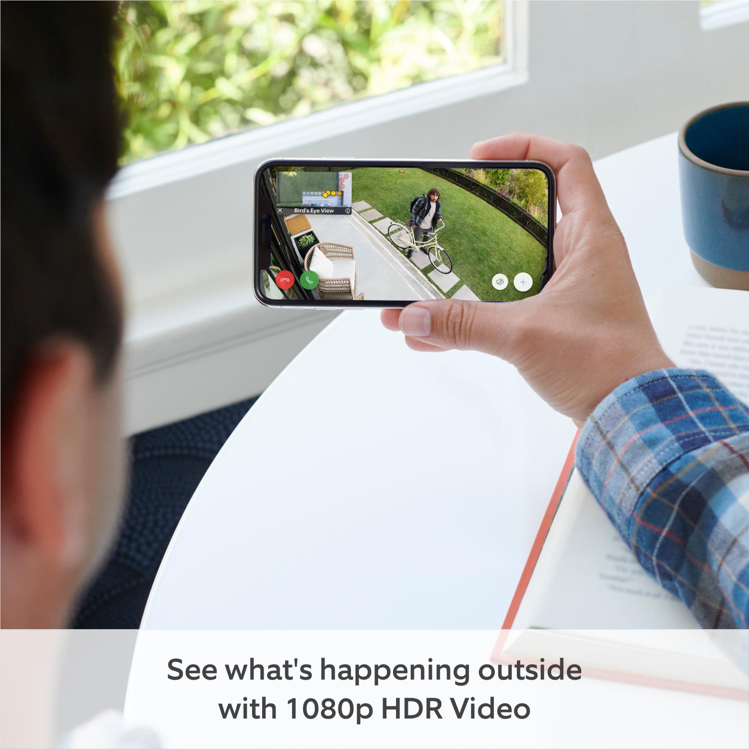 Black security camera with live view on smartphone held in hand