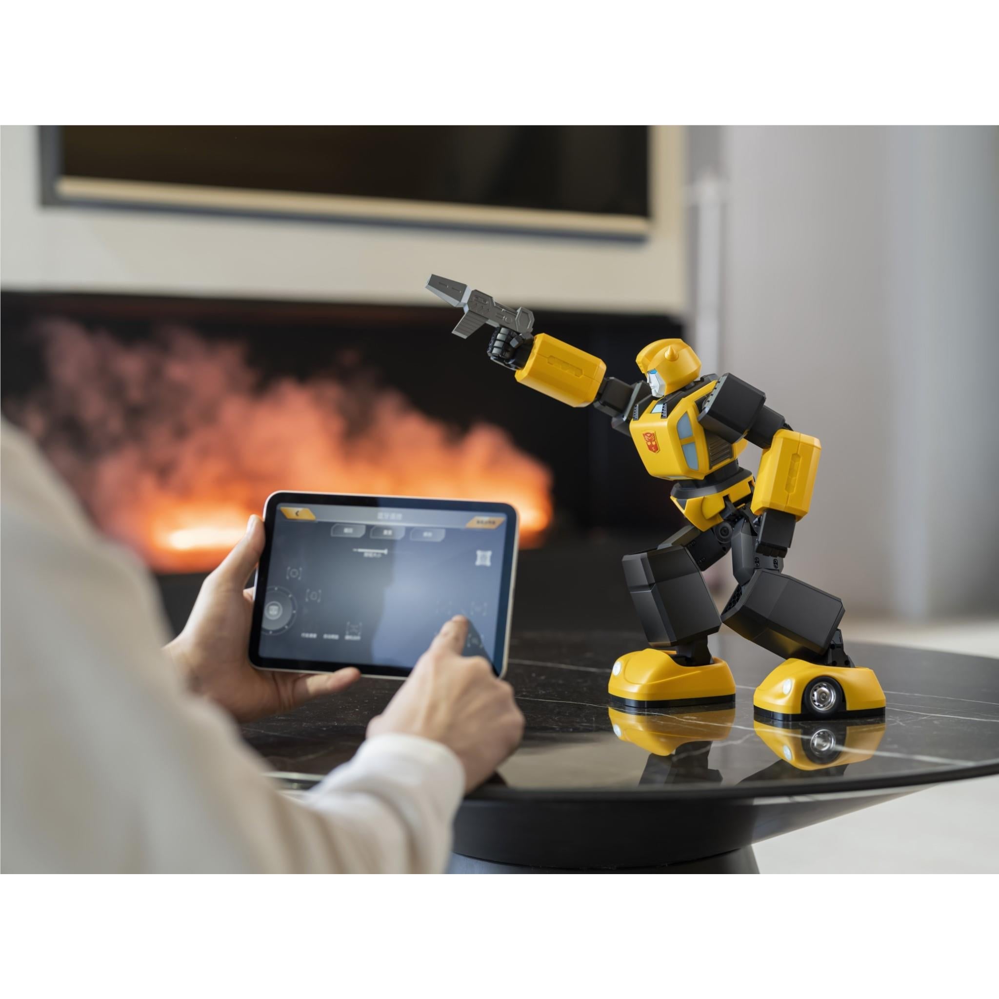 Bumblebee transformer robot on round base, user controlling with tablet near fireplace