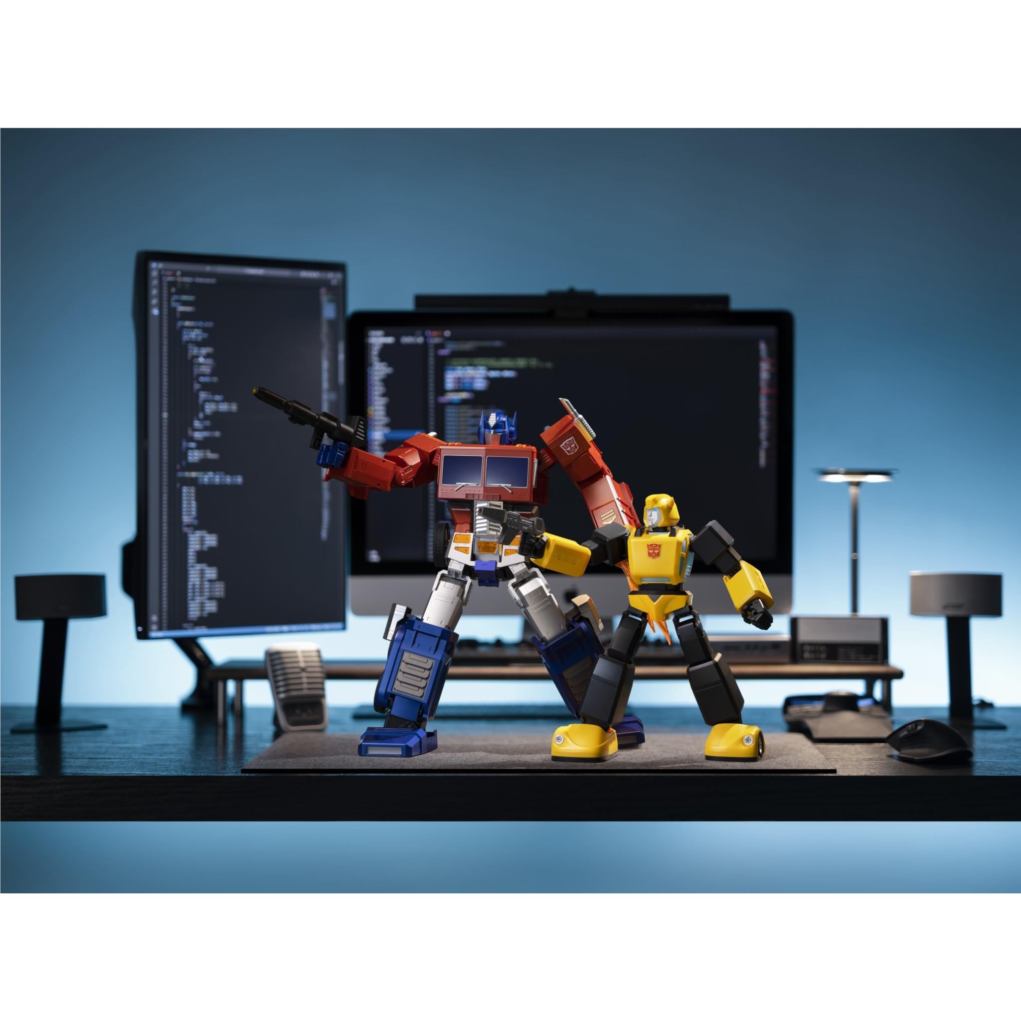 Bumblebee transformer robot collectible on desk, standing beside computer monitors