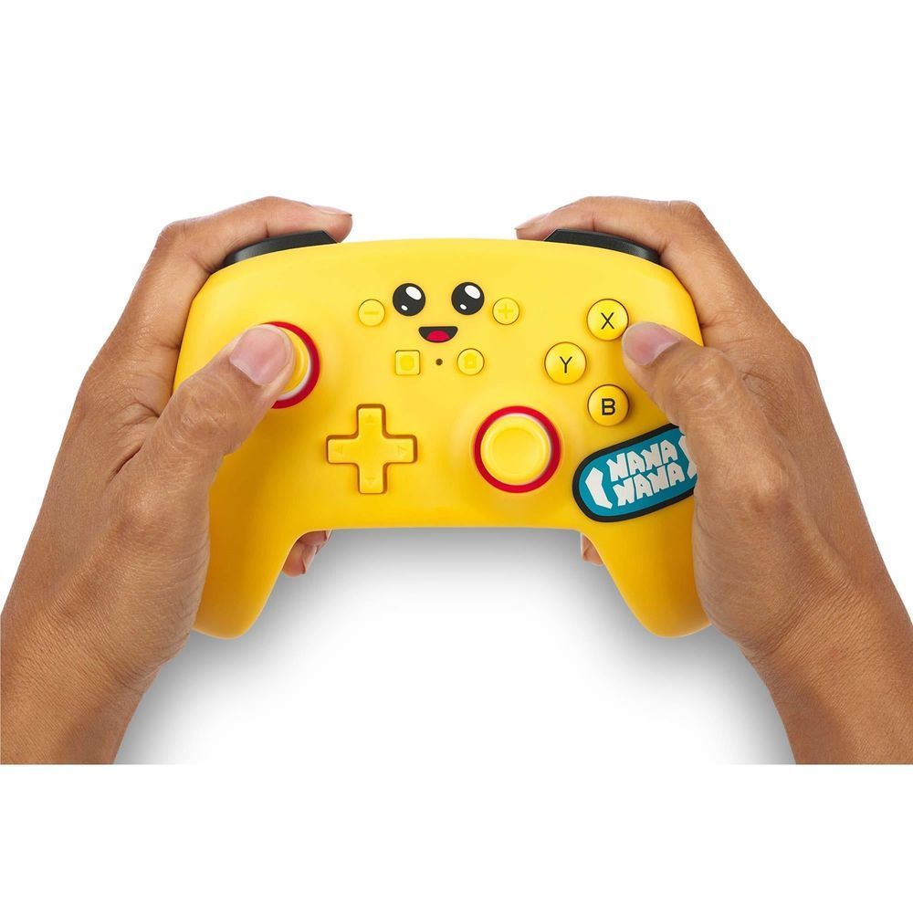 Yellow wireless game controller held in hands, showing ABXY buttons, sticks, and face graphic