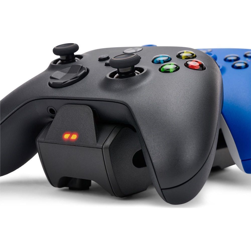 Black controller docked on charging station with glowing power indicator