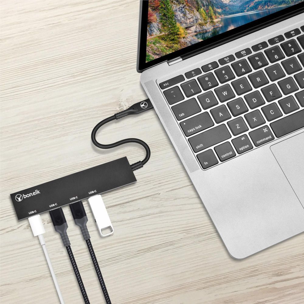 Black USB-C hub connected to laptop with braided cable and four USB-C ports