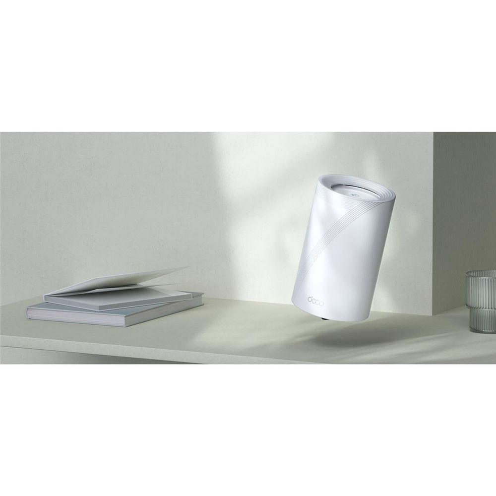 TP-Link Deco mesh Wi‑Fi node, white cylindrical unit on a tabletop with angled view