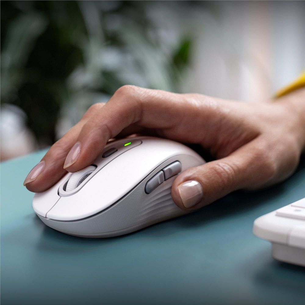 Off-white wireless mouse being held and used