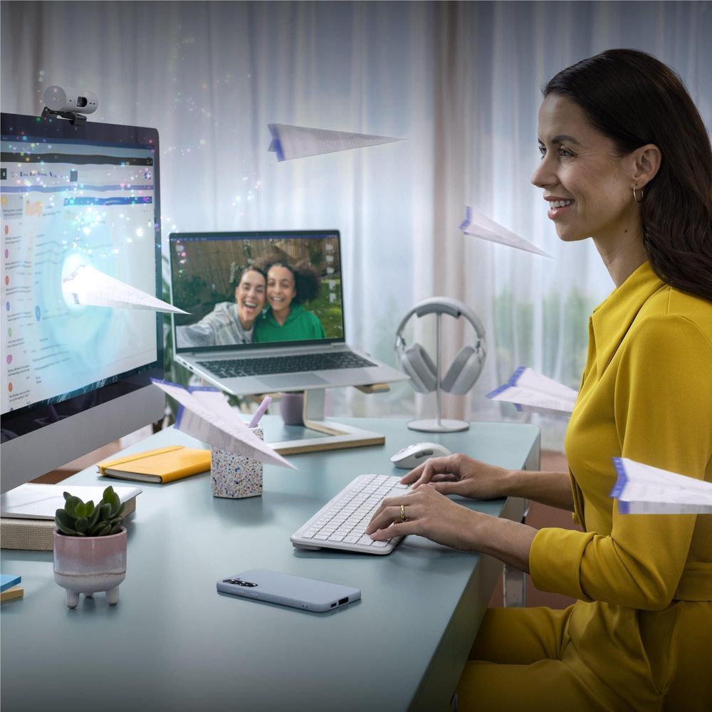 Off-white wireless keyboard and mouse on desk with person typing