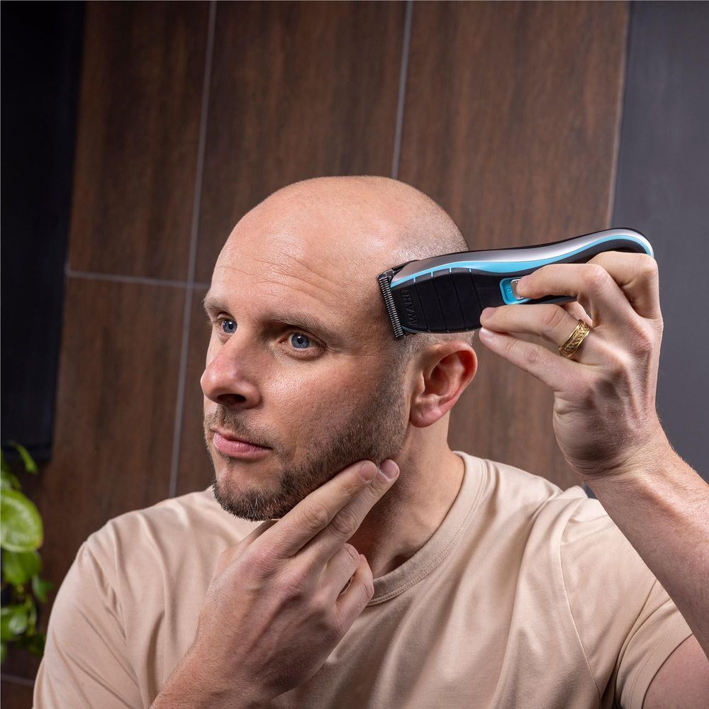 WAHL cordless clipper used on scalp, held by hand in black and blue