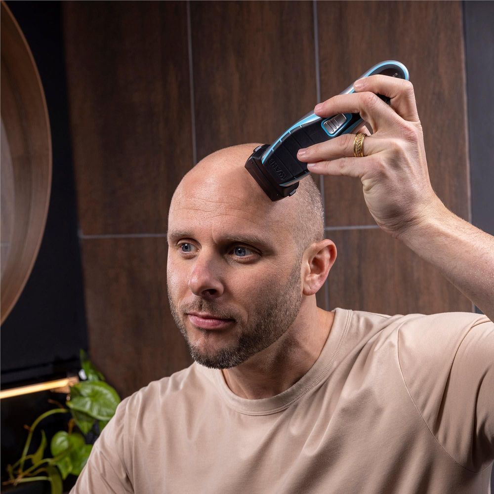 WAHL cordless clipper used on hairline, held in hand with black and blue body