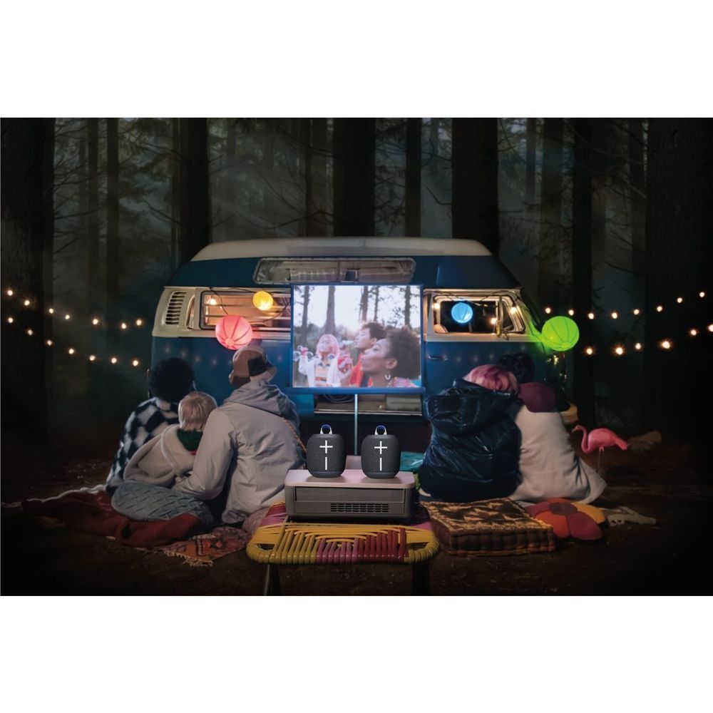 Black portable Bluetooth speaker with plus icons on a vehicle dashboard