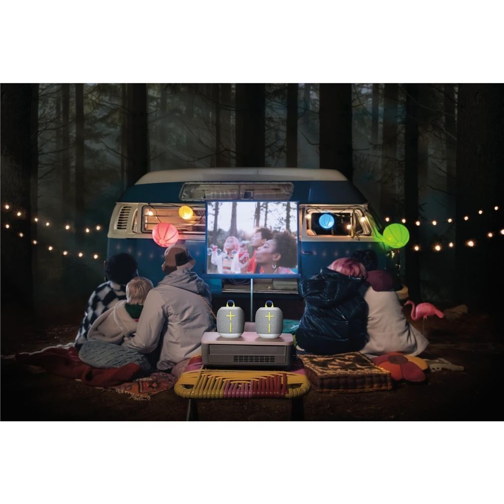 Gray portable Bluetooth speaker on tabletop with lime handle strap