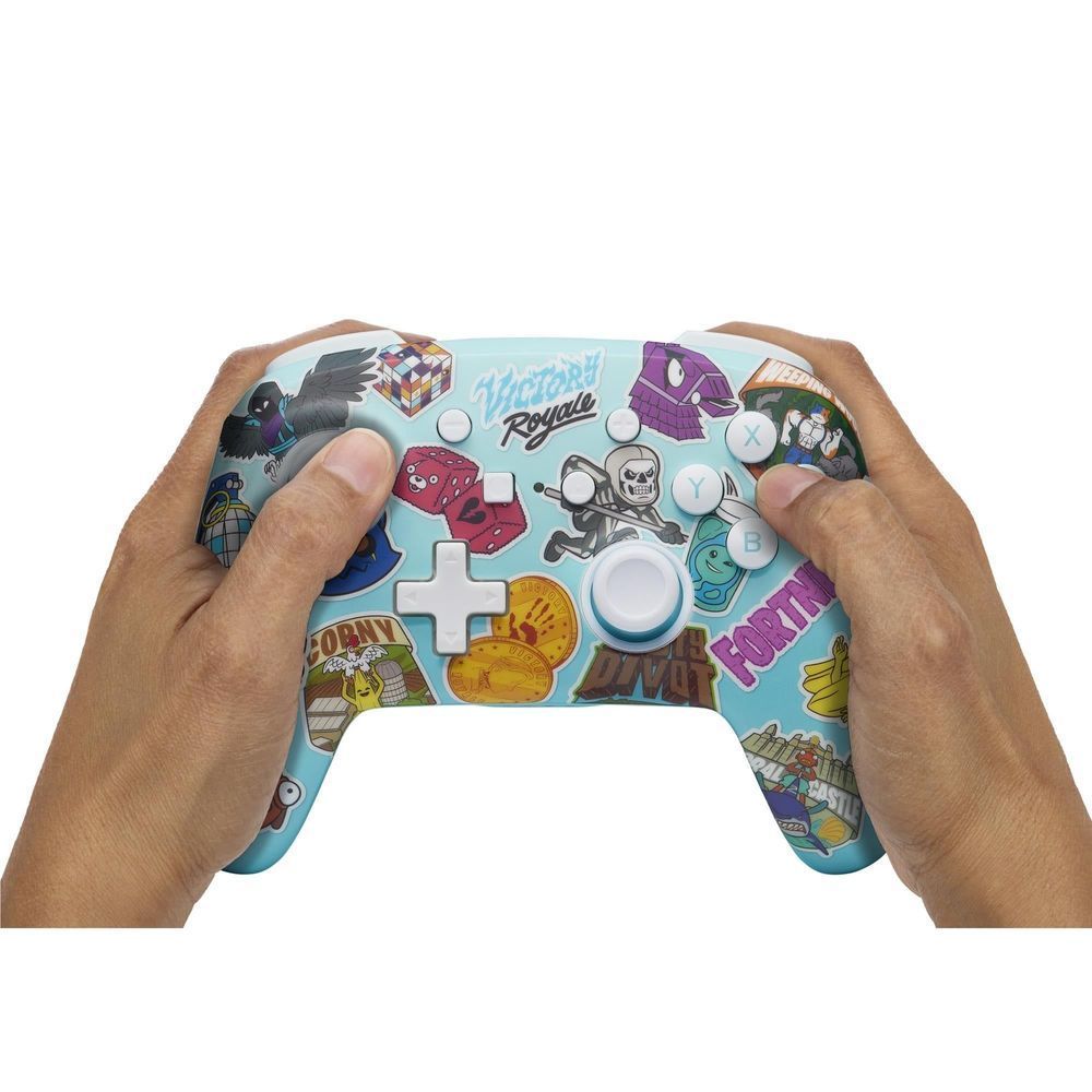 Hands holding light blue wireless controller showing Fortnite sticker buttons and thumbsticks