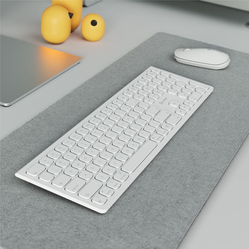 White wireless keyboard on gray felt mat, low-profile keybed