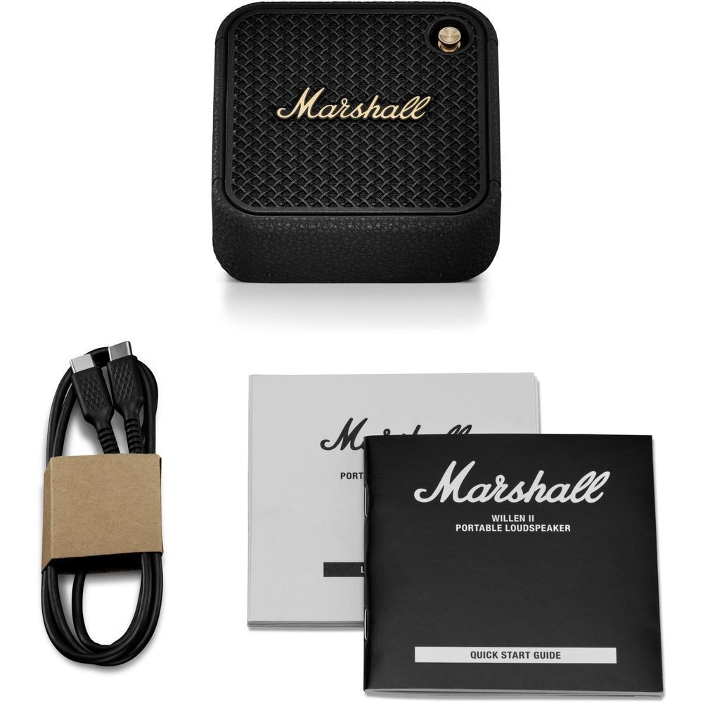 Black portable Bluetooth speaker and included accessories with guides in packaging