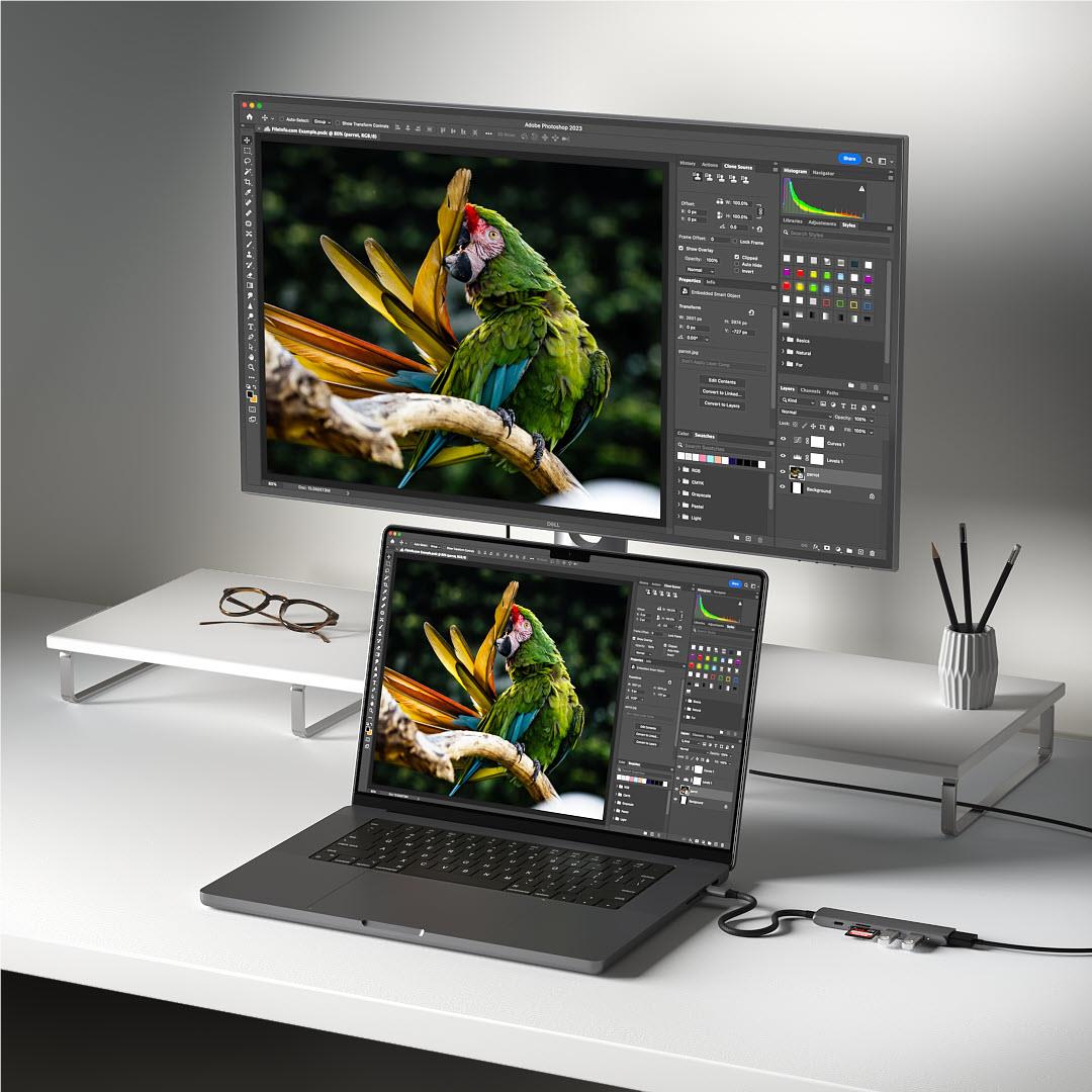 USB-C multiport hub connected to laptop and monitors, cables routed on desk