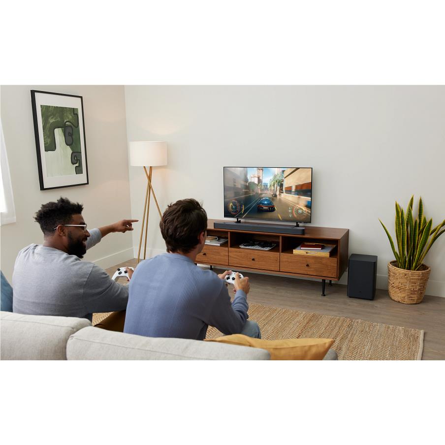 People watching TV with black soundbar and wireless subwoofer for home audio.
