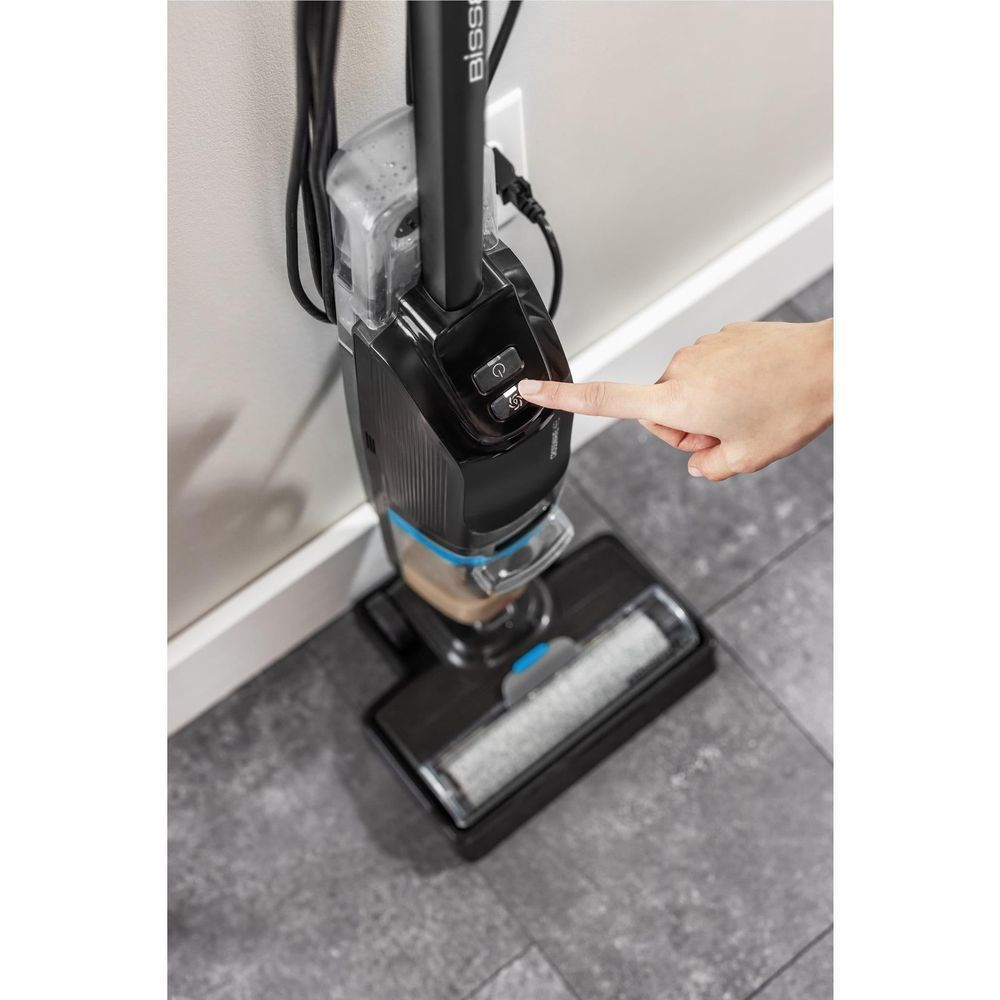 Upright wet and vacuum cleaner base with blue control and hand adjusting the head.