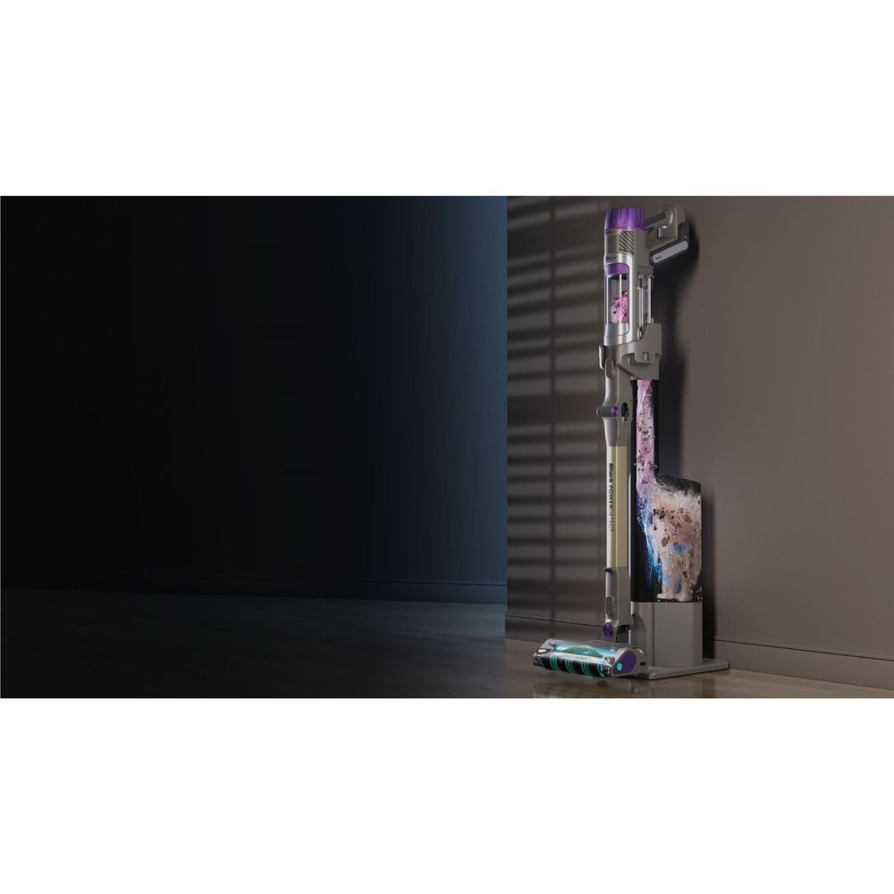Cordless stick vacuum standing upright with purple canister and clear dirt compartment
