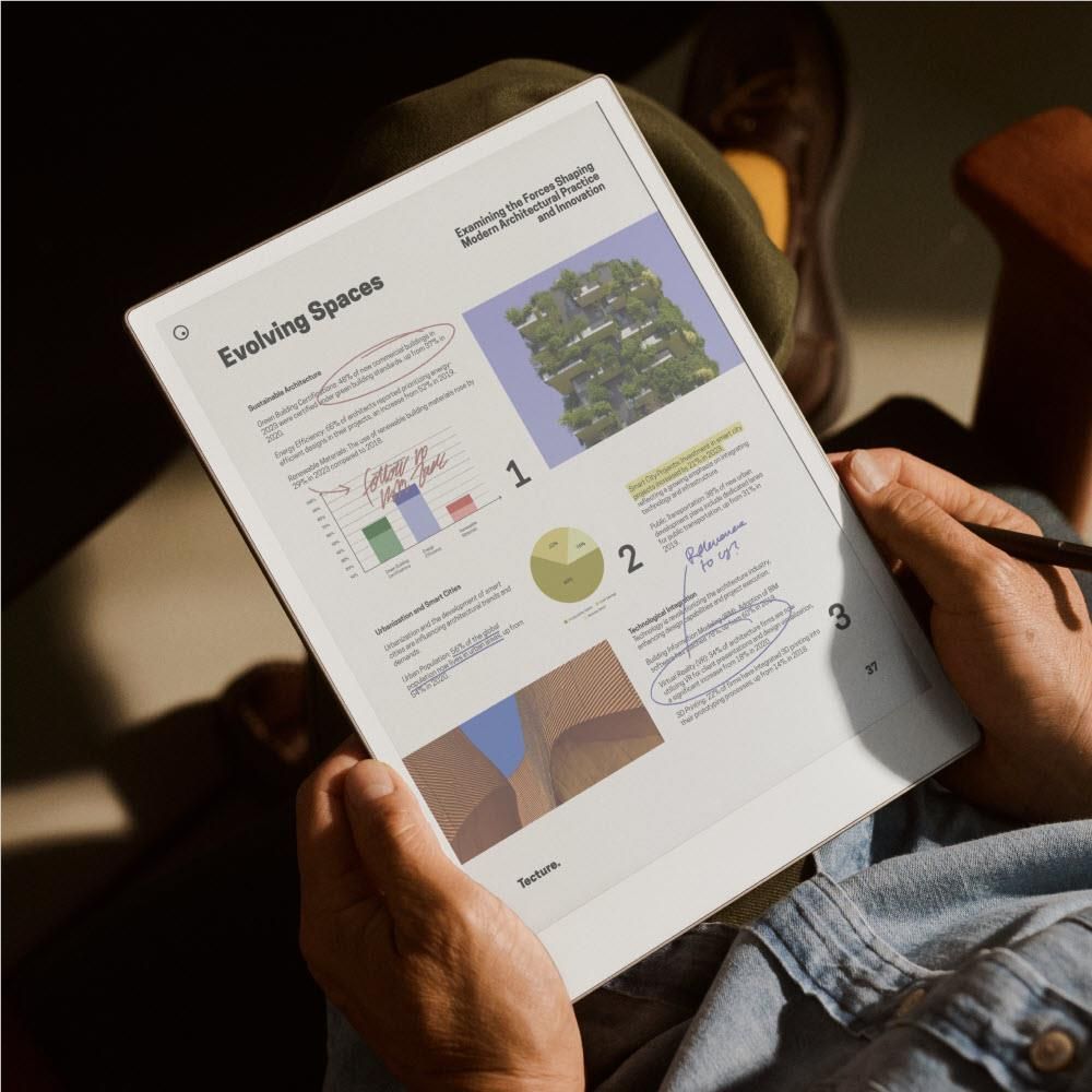 Hands holding an e-paper tablet showing a presentation-style document