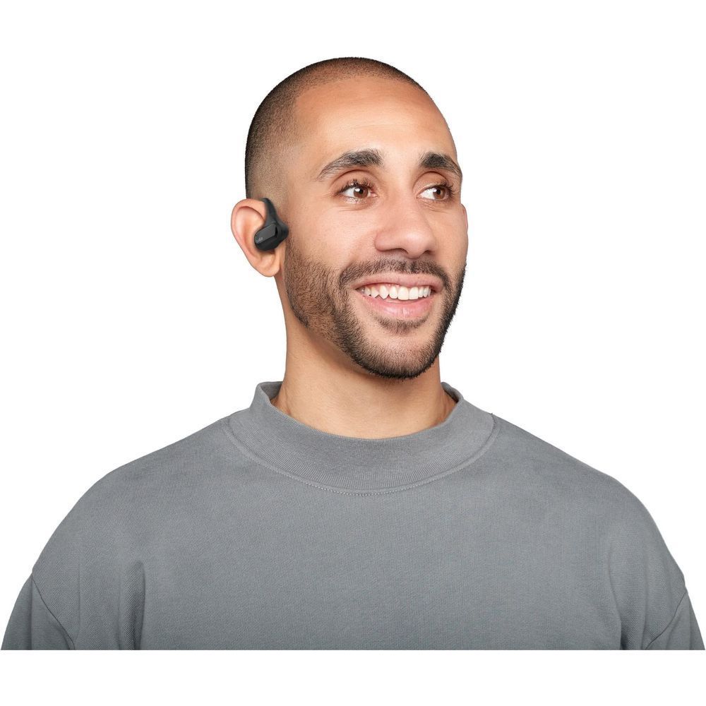 Man wearing black open-ear true wireless earbuds with curved ear hooks
