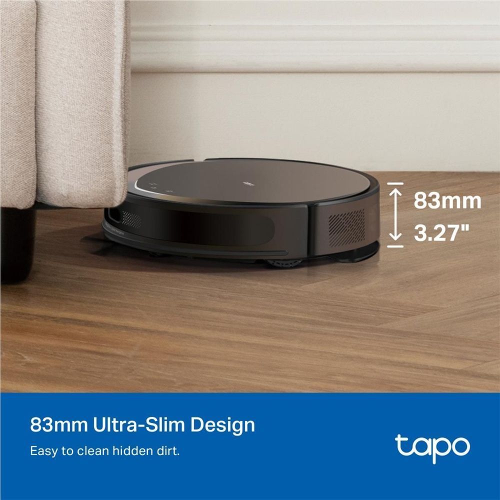 Black ultra-slim robot vacuum on wood floor next to couch base, low profile