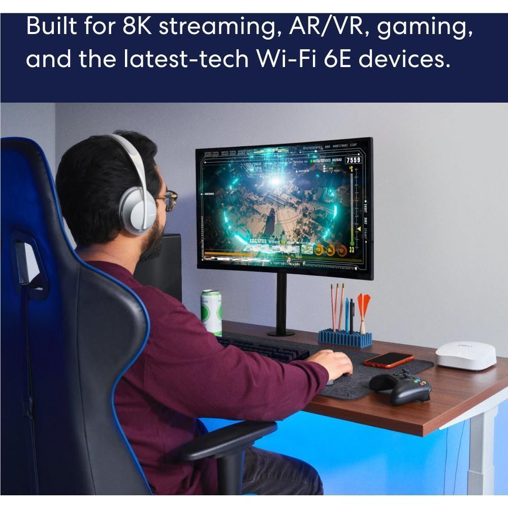 White eero mesh Wi-Fi router node on a desk near a gaming setup