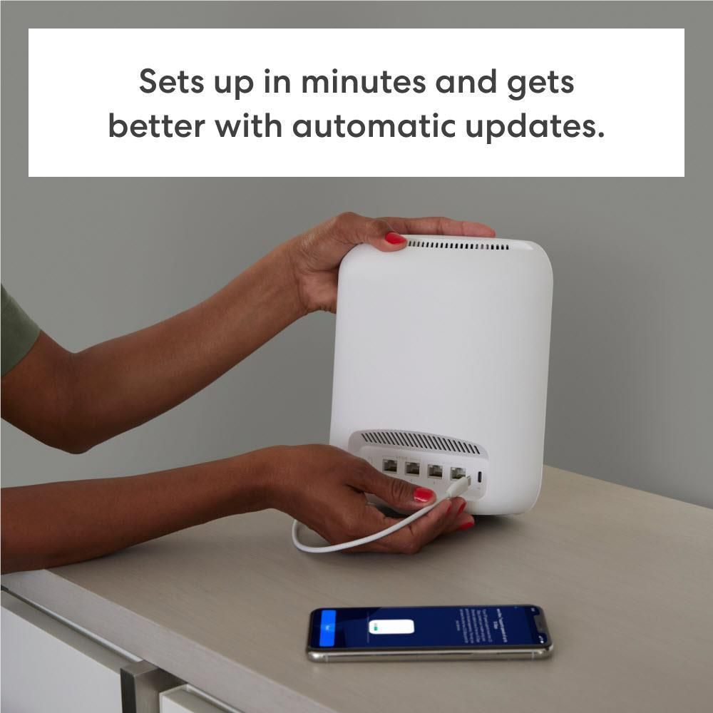Hands installing eero Max 7 Wi-Fi 7 mesh router, ports facing down