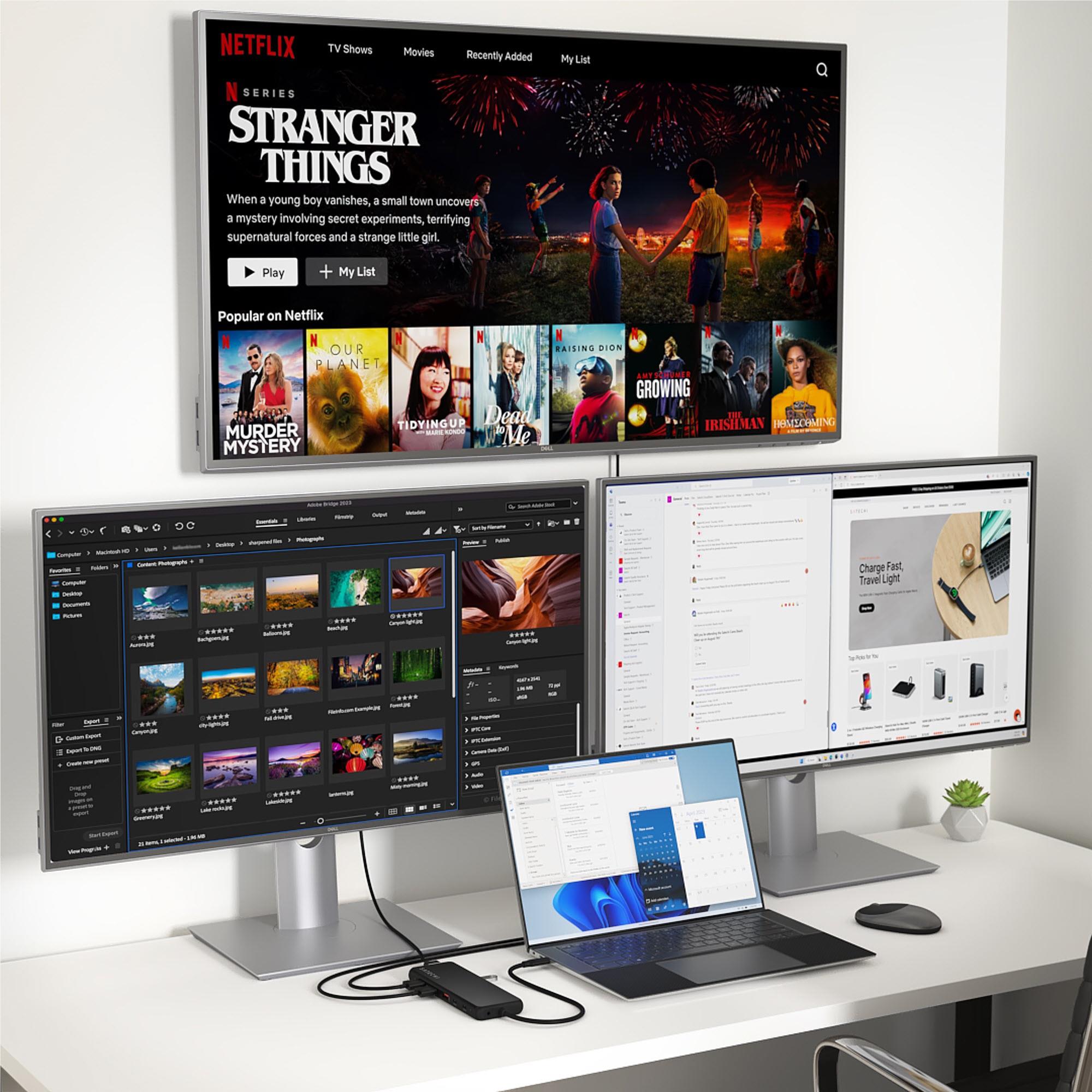 Black USB-C multiport hub connected to monitors and laptop on desk