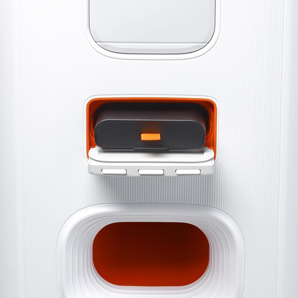 White speaker with open battery and accessory compartment, showing orange interior