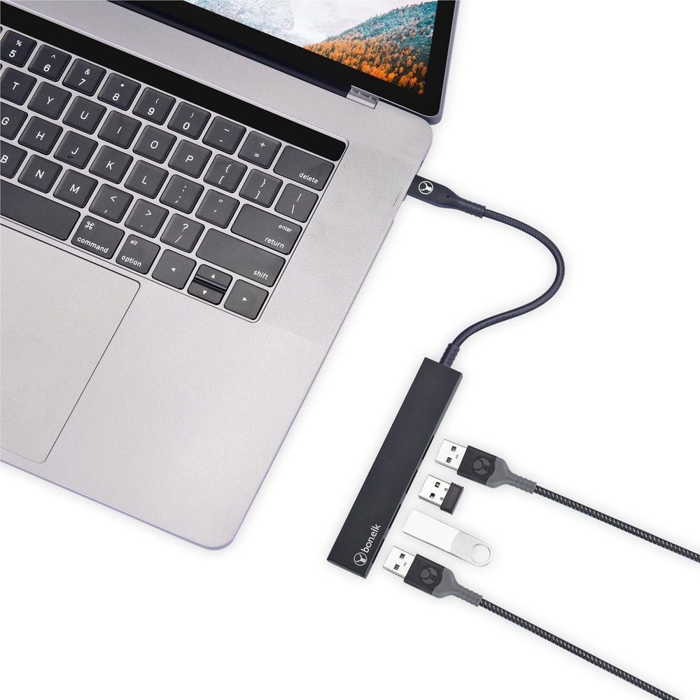 Black 4-port USB 3.0 hub connected to a laptop with USB devices