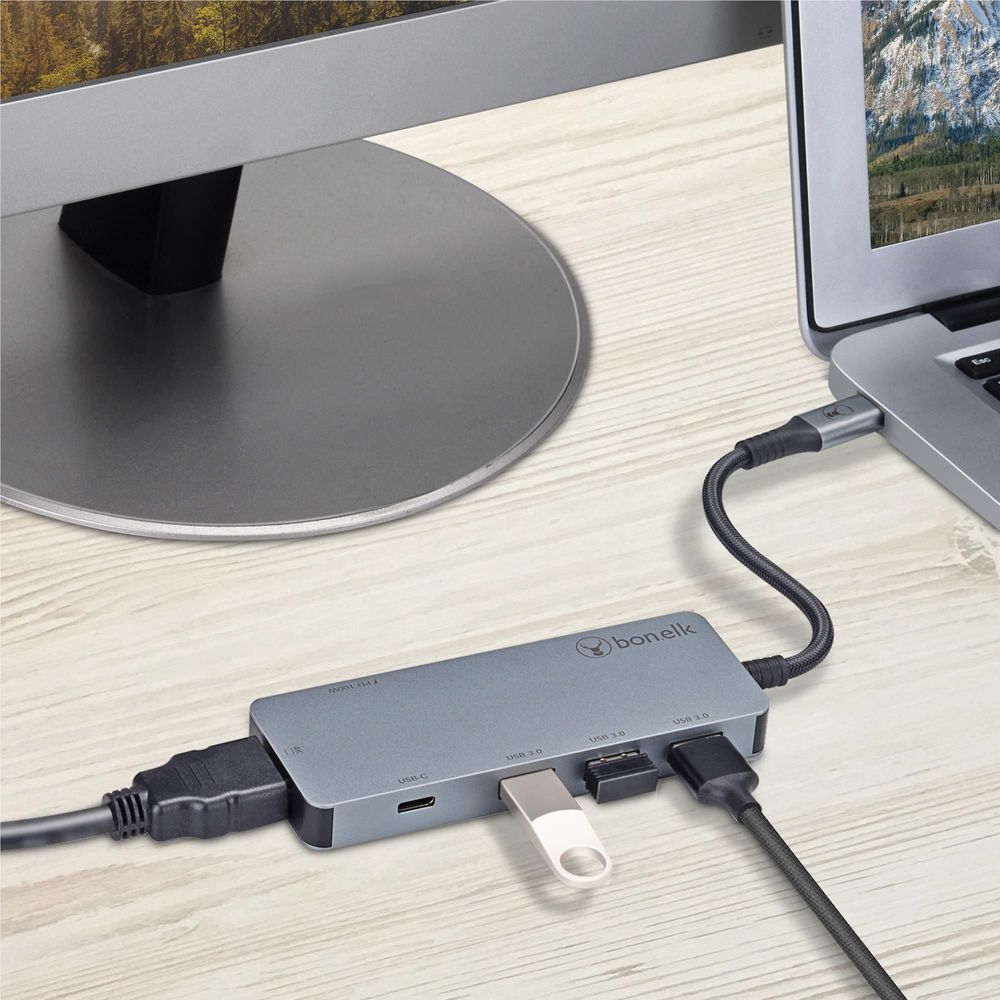 Space grey USB-C multiport hub on desk with ports connected to monitor