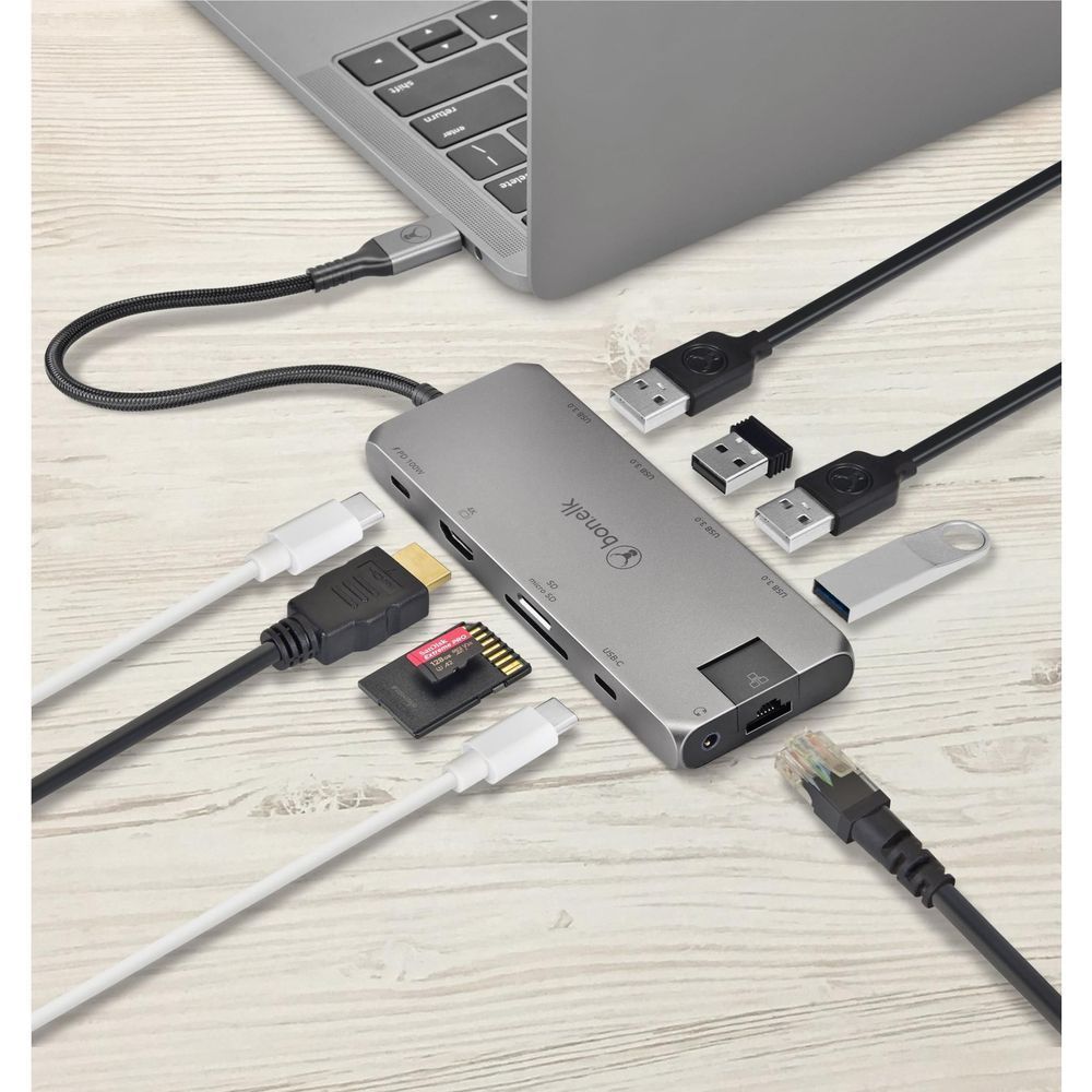 Space gray USB-C hub on desk with multiple device ports and cables connected
