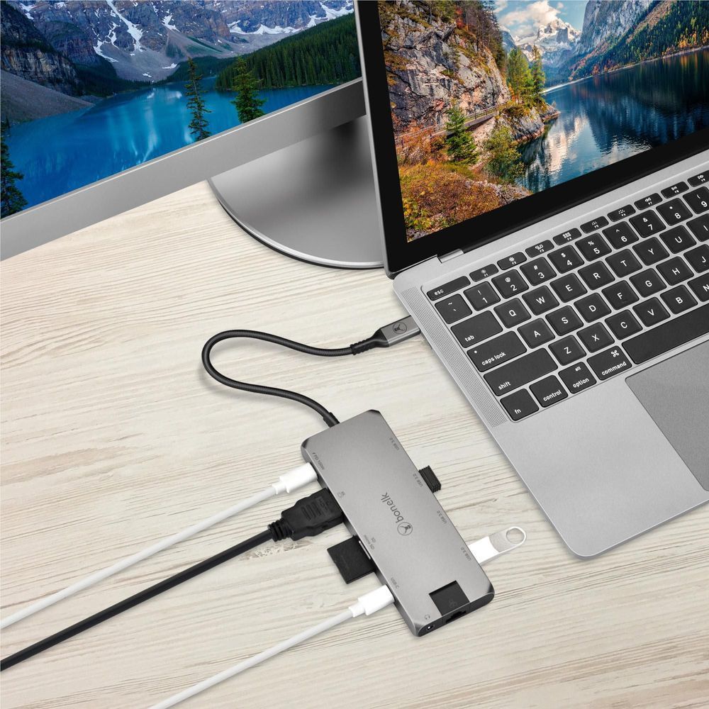 Space gray USB-C hub connected to laptop with multiple attached cables
