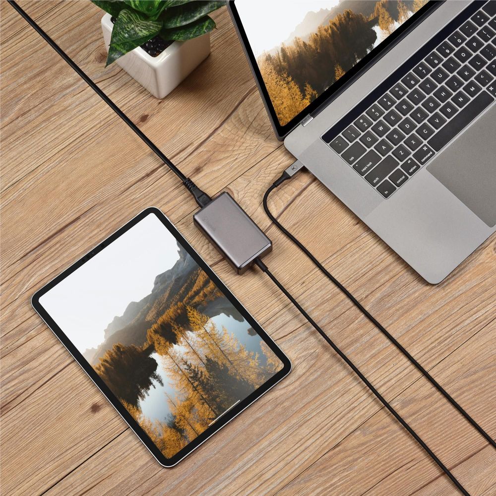 Space gray charger with built-in cable powering a tablet and phone