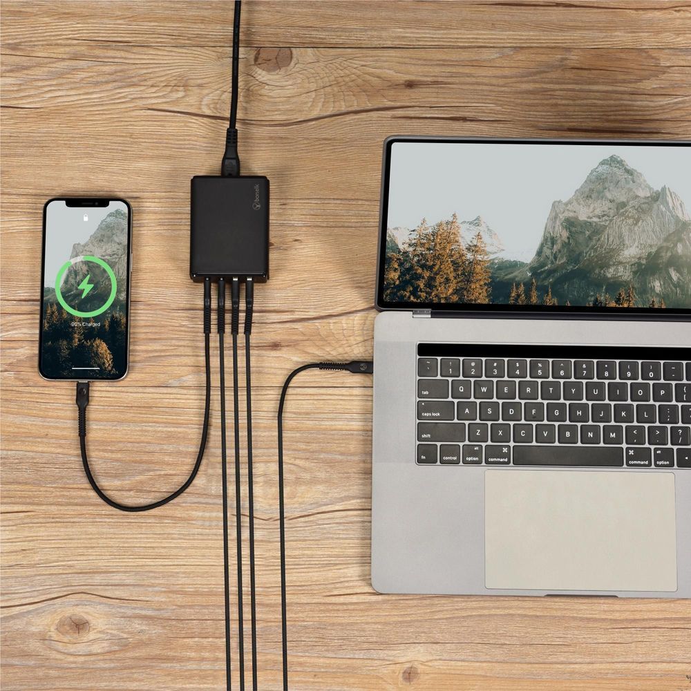 Black desktop charger connected to phone and laptop with multi-connector cable
