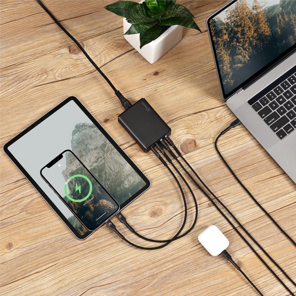Black desktop charger with cable powering phone and laptop from USB ports
