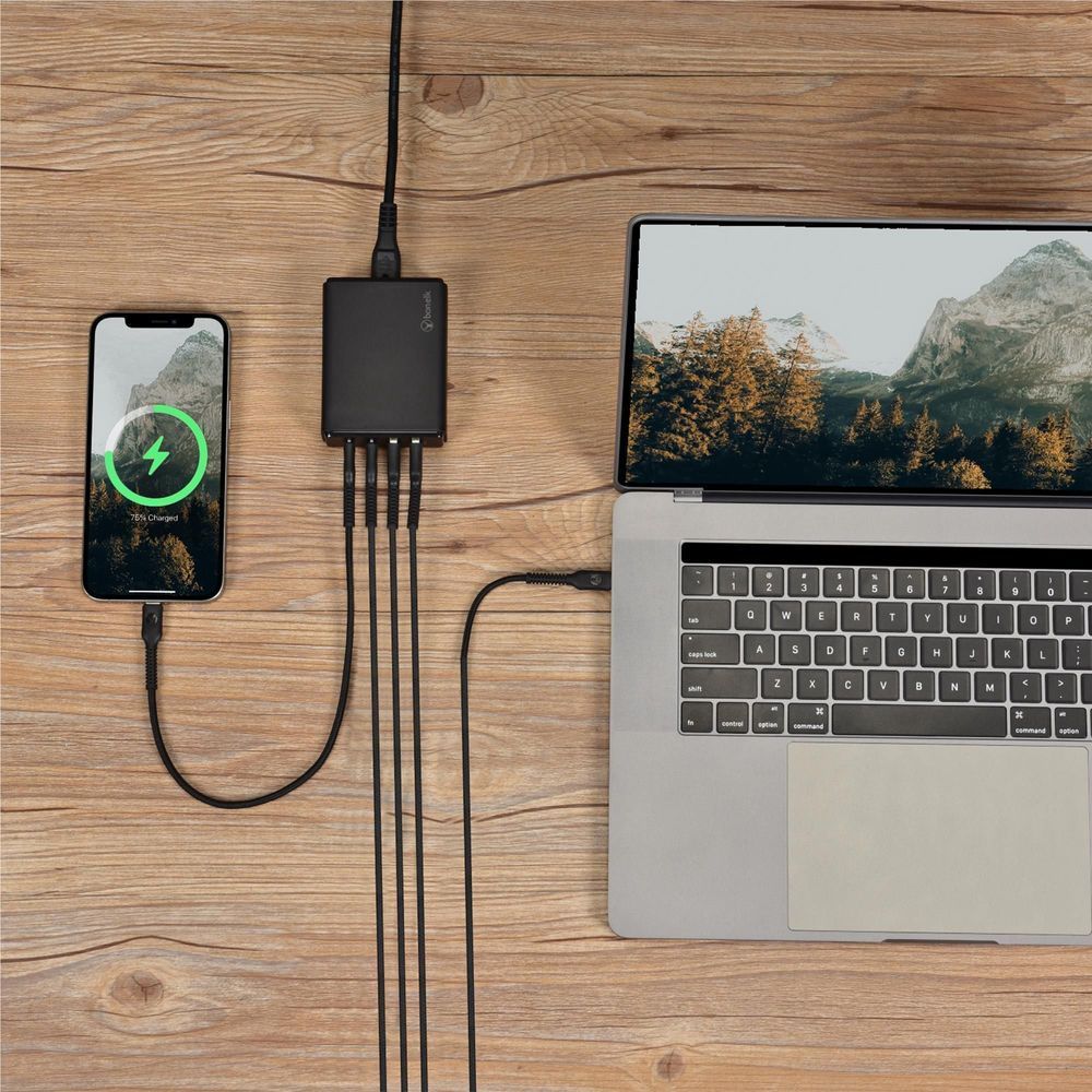 Black 65W desktop GaN charger plugged in with cable to phone and laptop
