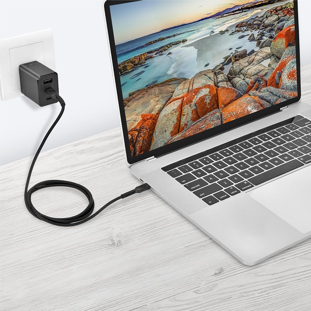 Black USB-C to USB-C cable plugged into a wall charger and laptop