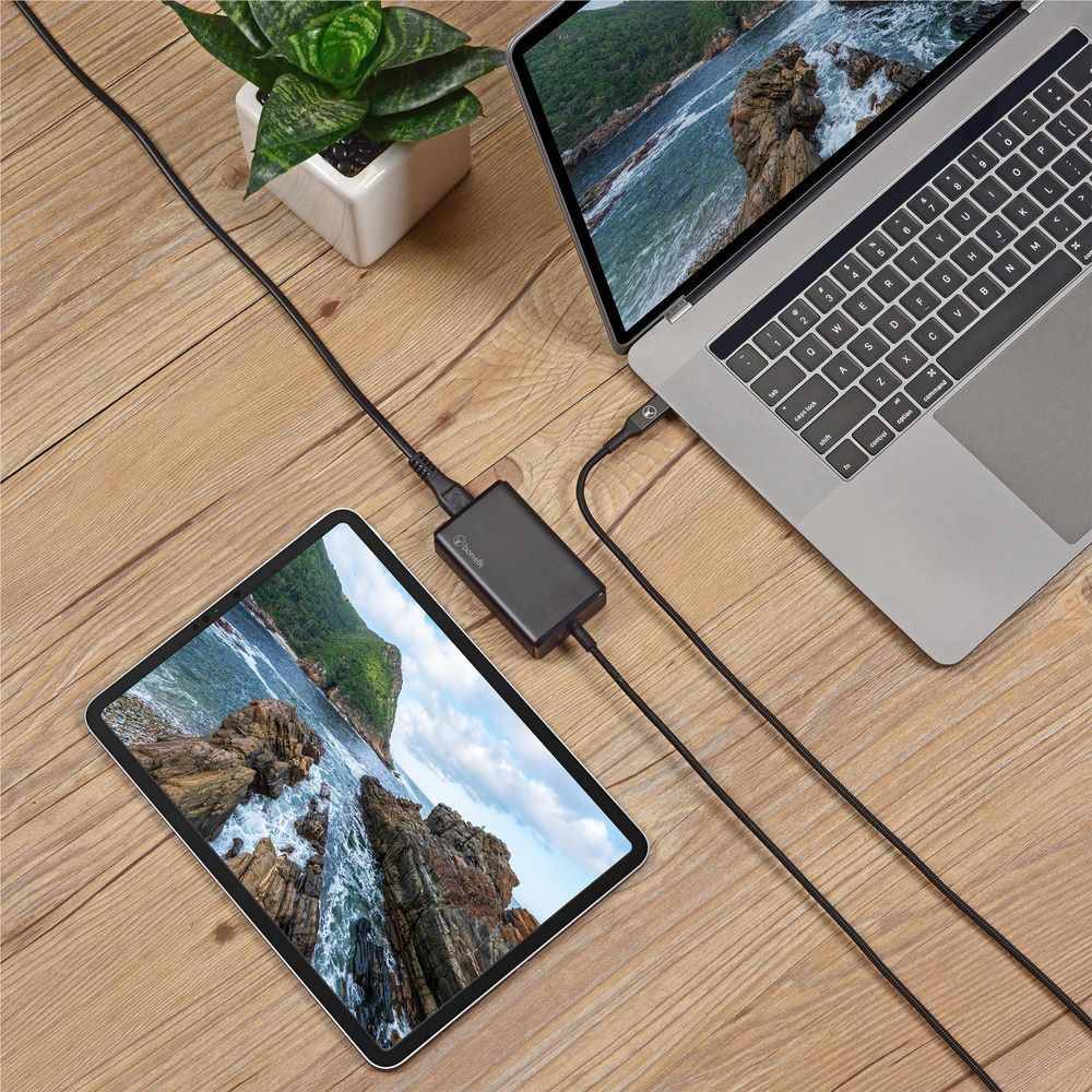 Black desktop PD charger with USB-C cable powering a tablet and connected laptop