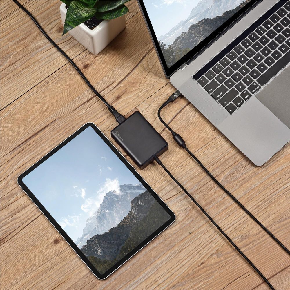 Black GaN desktop charger with built-in cable connected to tablet and smartphone