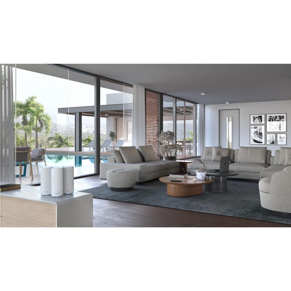 White Orbi mesh Wi‑Fi router nodes placed in a modern living room