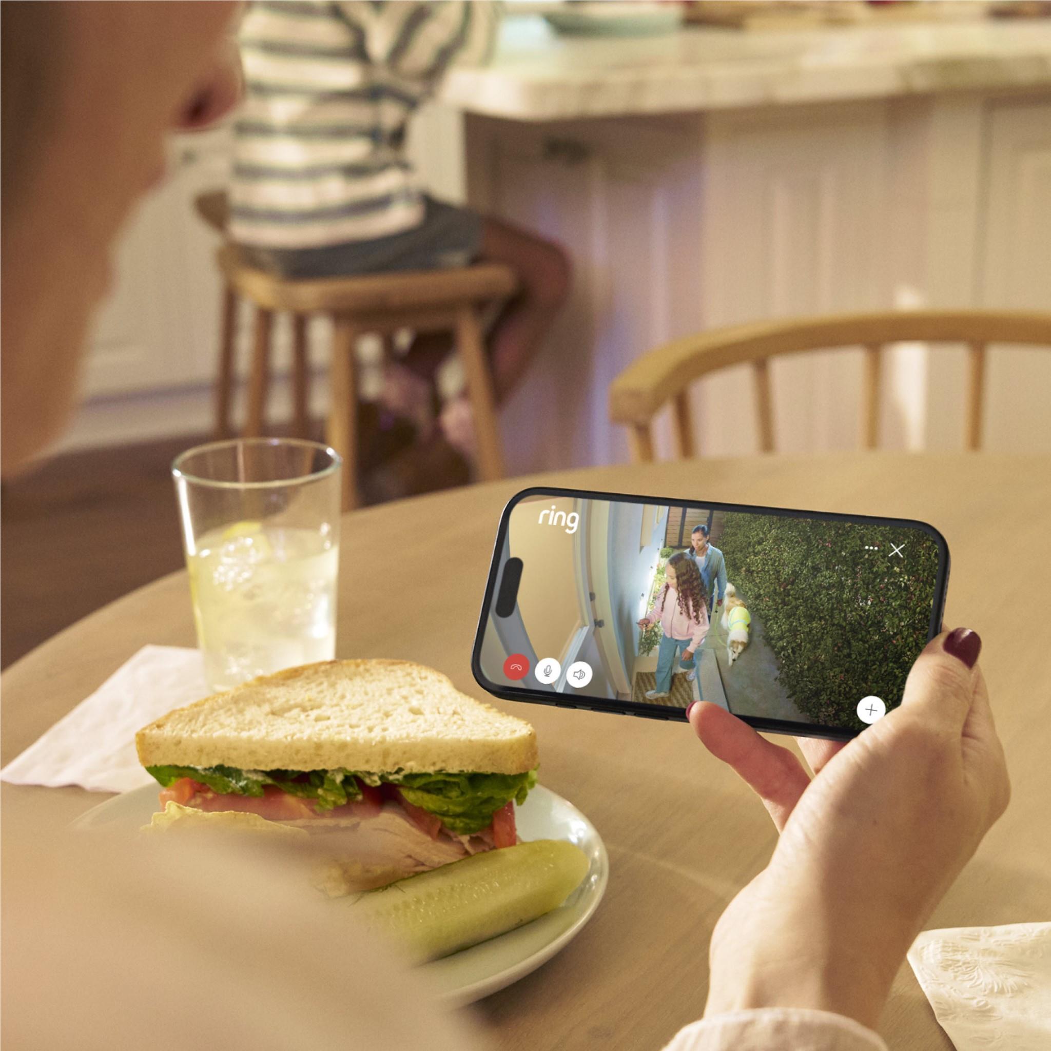 Smartphone displaying live view from a black outdoor security camera