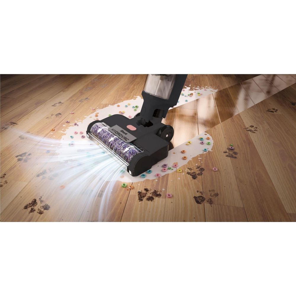 Floor cleaning nozzle dispensing spray while cleaning a wood surface