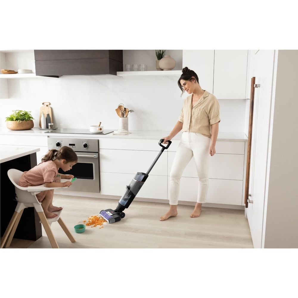Cordless wet/dry vacuum with clear tank and floor brush head on kitchen flooring