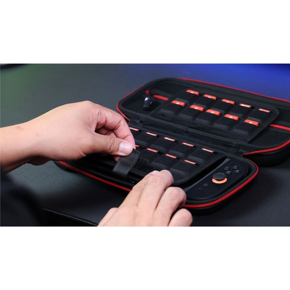 Hands place controllers in open black carry case with red elastic holders