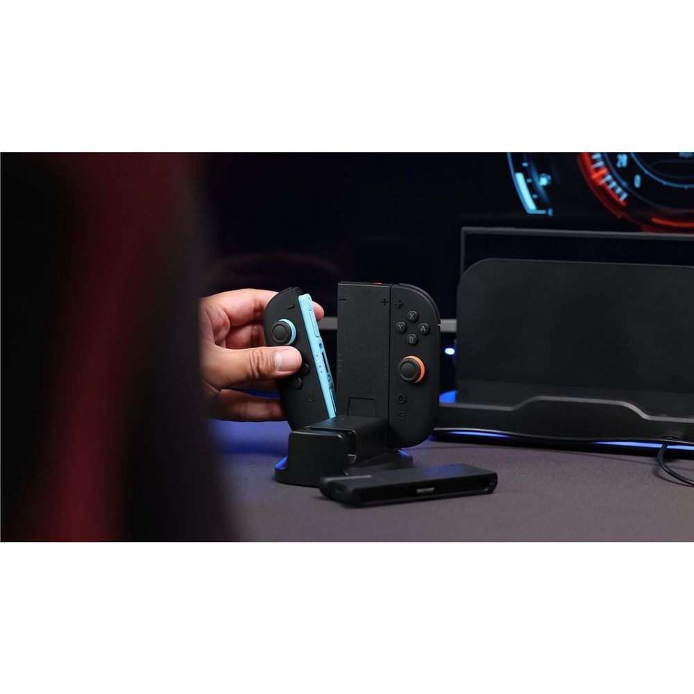 Hand placing a controller onto a black dual grip charging dock with LED lights