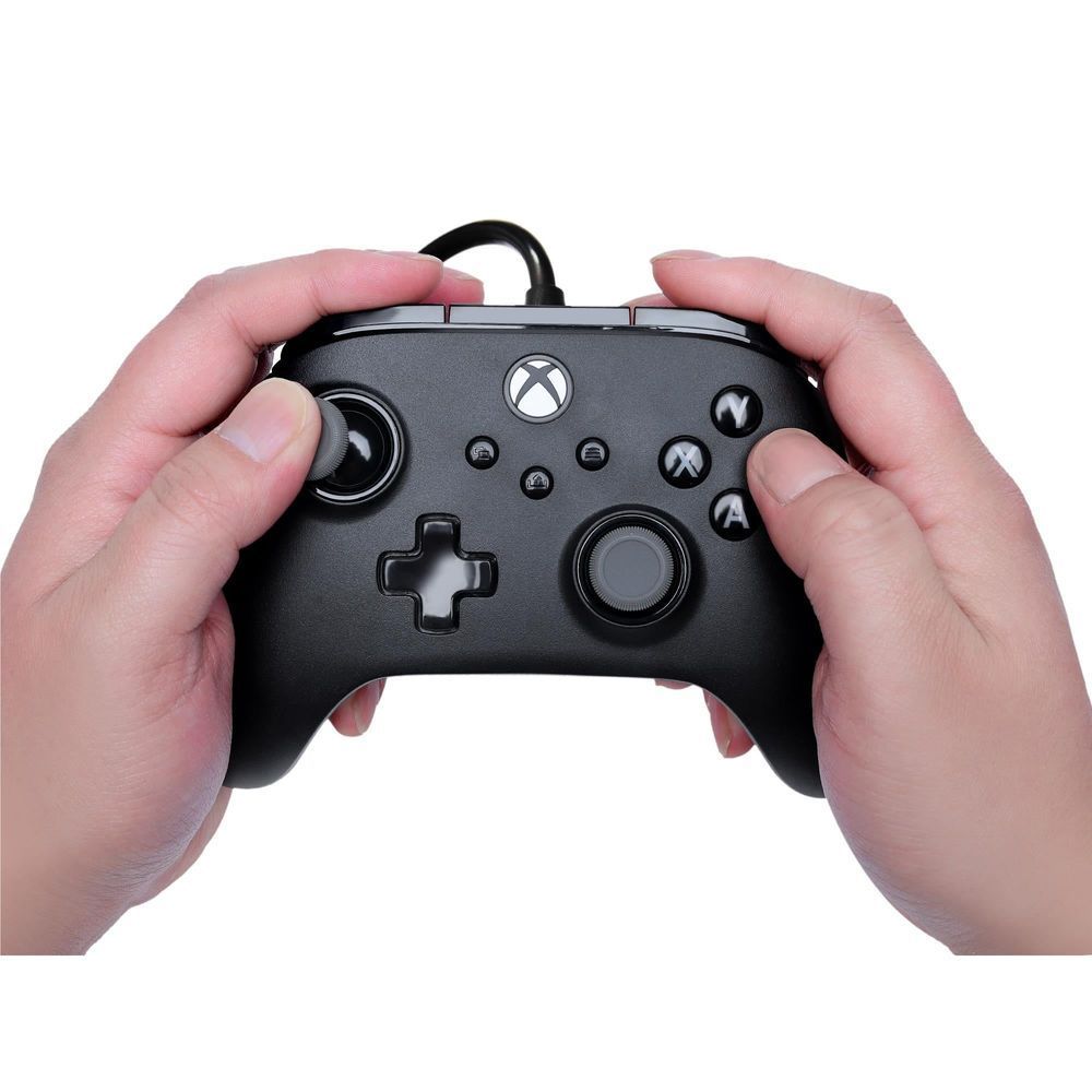 Black wired Xbox controller held in hands with analog sticks, D-pad, and face buttons