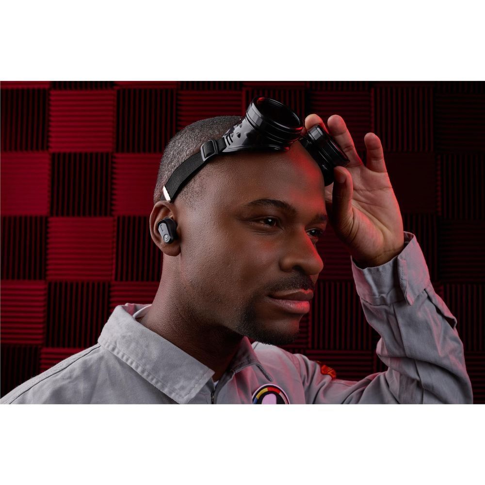 Wireless earbuds worn in-ear on a man in a studio